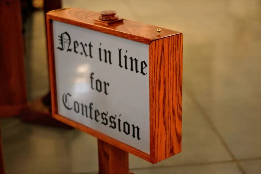 sign reading "next in line for confession" to represent how to get over Catholic guilt