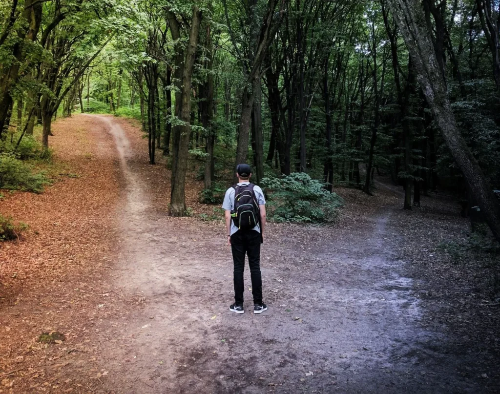 Person facing two roads to depict religious deconstruction therapy