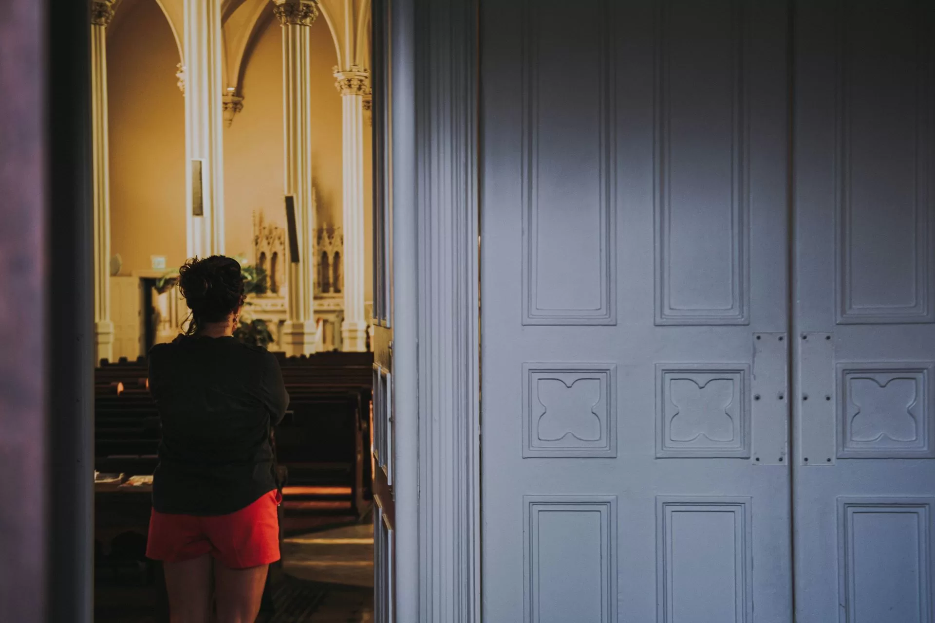 Person standing in the back of a church to represent religious trauma in texas