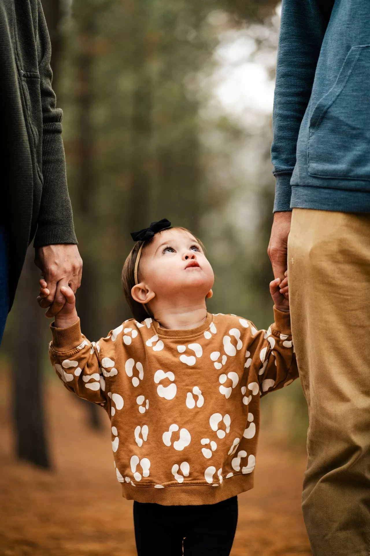 child holding parent's hands to represent parenting styles that contribute to religious trauma